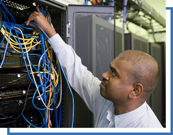 A man working on wires in an office.