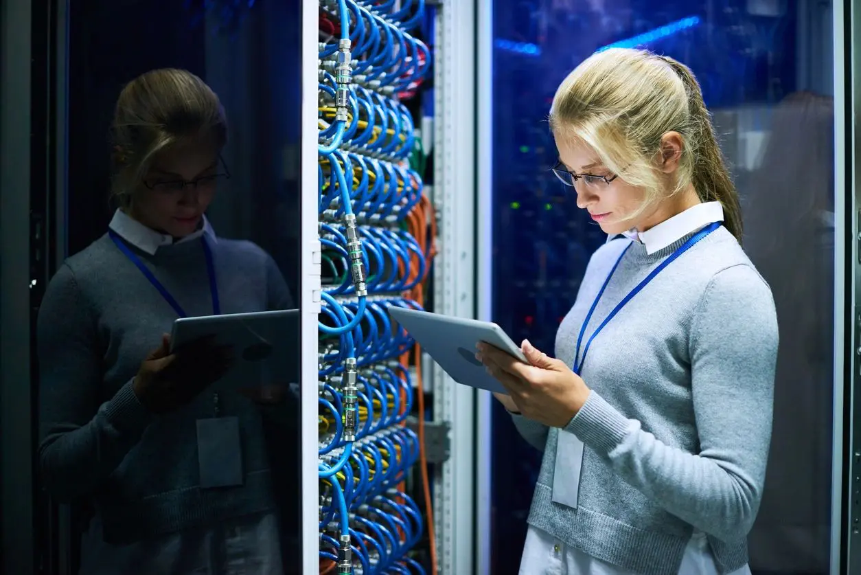 A woman is looking at her tablet in front of the server.